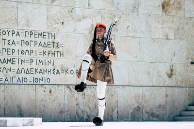 Full length of woman standing against wall