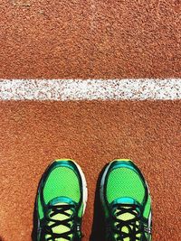 Low section of athlete standing on running track