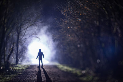 Rear view of silhouette man walking on street