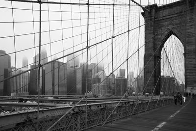 View of suspension bridge in city against sky