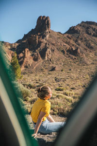 Woman seen through tent against mountains