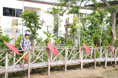 Man sitting by plants against trees