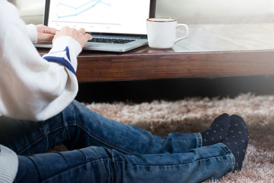 Low section of man using laptop