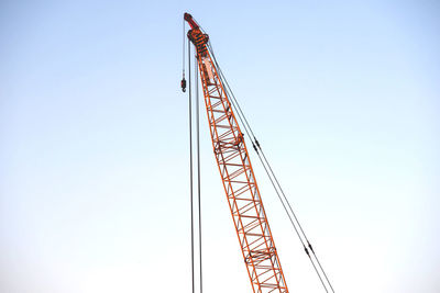 Low angle view of crane against clear sky