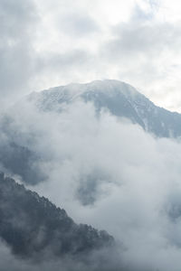 Low angle view of snow covered mountains against sky