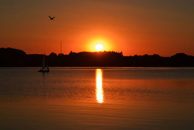 Scenic view of ratzeburger see lake against orange sky