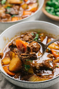 Beef stew presented on a spoon