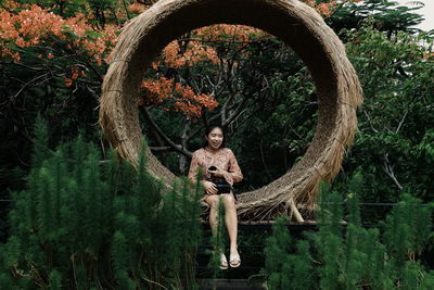 Portrait of boy standing by tree