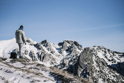 Rear view of person standing on snow covered landscape