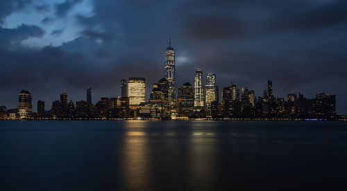 Illuminated buildings in city against sky