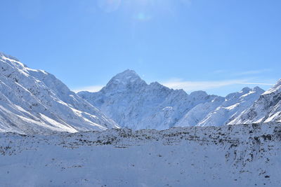 Scenic view of snowcapped mountains against blue sky