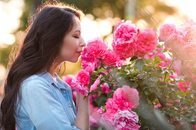 Woman smelling flowers on tree outdoors