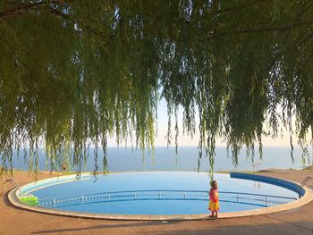 Boy standing by swimming pool