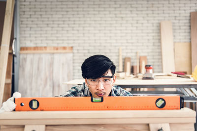 Man with hand tool working on workbench