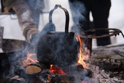 Close-up of tea kettle on bonfire in forest
