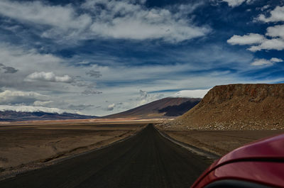 Road amidst desert against sky