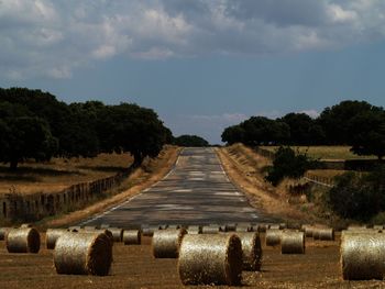 Hay bales on field against sky