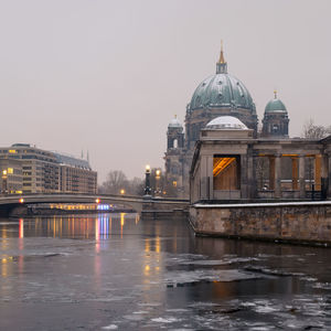 View of illuminated city at riverbank