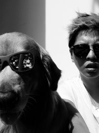 Close-up of dog and woman wearing sunglasses