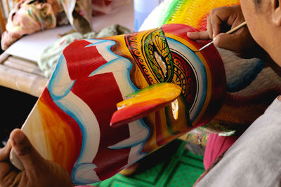 Close-up of man holding multi colored hands