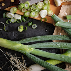 Fresh negi, japanese green spring onions, chopped scallions on wooden cutting board, flat lay.