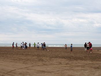 Scenic view of beach against cloudy sky