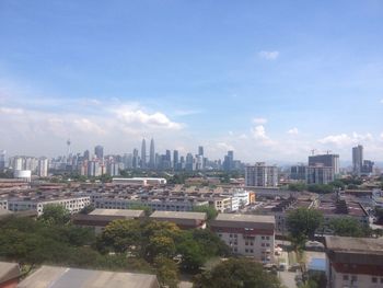 View of cityscape against cloudy sky