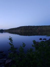 Scenic view of lake against clear blue sky