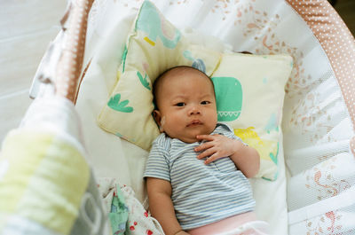 High angle view of baby lying on bed