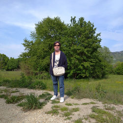 Portrait of young man standing on land against sky