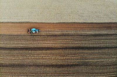 High angle view of tractor ploughing field