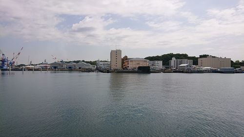 Buildings by sea against sky