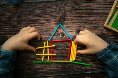 Cropped image of man holding toy blocks on table