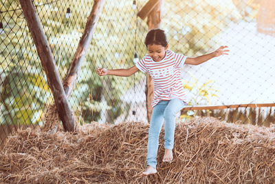 Full length of a boy playing with fence