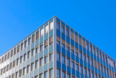 Low angle view of modern building against clear blue sky