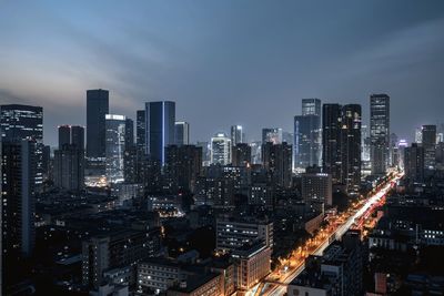 Illuminated cityscape against sky at night