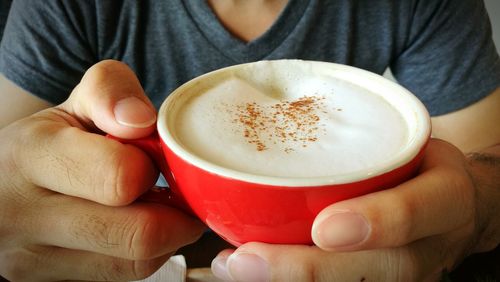 Close-up of hand holding coffee cup