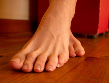 Low section of woman feet on wooden floor