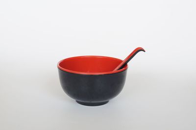 Close-up of red wineglass against white background