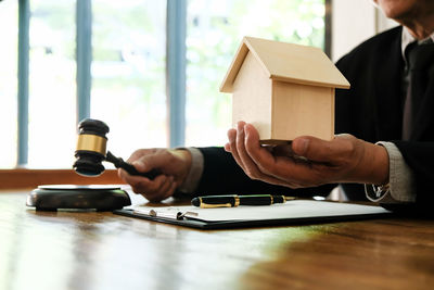 Midsection of man holding camera on table