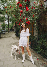 Portrait of young woman with dog on street