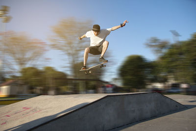 Portrait of skateboarder jumping in skate park