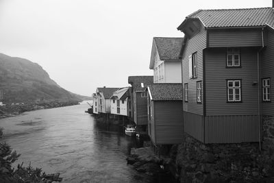 Houses by sea against clear sky