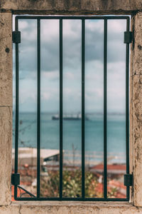 Close-up of metal railing against sea