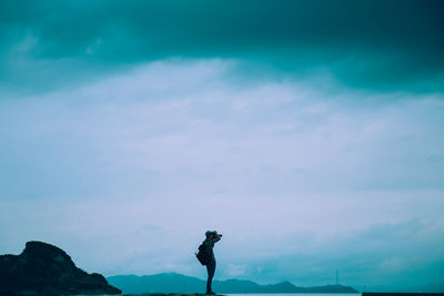 Man standing on landscape against blue sky