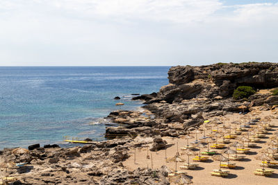 Scenic view at kalithea beach on geek island rhodes with rocky coastline and sunshades
