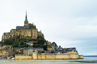 Mont saint-michel by beach against sky