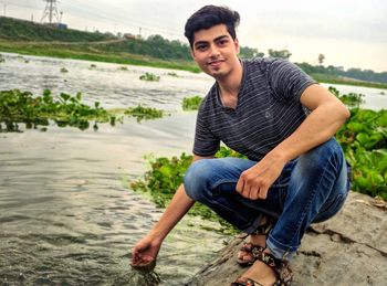 Portrait of young man sitting on land