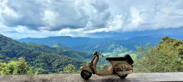 Panoramic view of people looking at mountains against sky