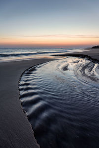 Scenic view of beach against sky during sunset